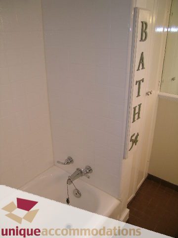 Bathroom with white tiles and a bathtub. - 4177 West 15th Avenue, Vancouver West Side