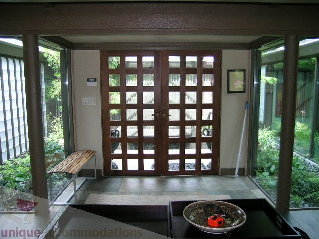 Furnished living room with sliding glass doors, wooden bench, and natural light. - 455 Keith Road, West Vancouver