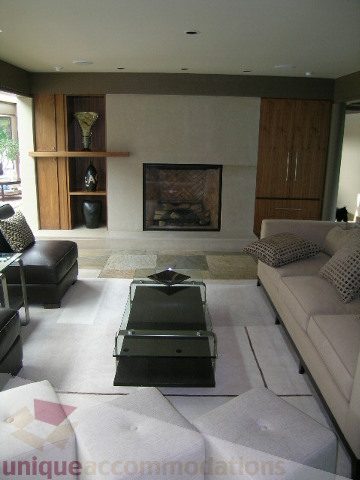 Spacious living room with modern furniture, fireplace, and large windows. - 455 Keith Road, West Vancouver
