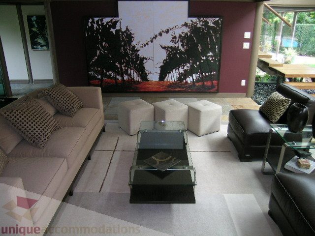 Furnished living room with modern furniture, large artwork, and glass coffee table. - 455 Keith Road, West Vancouver