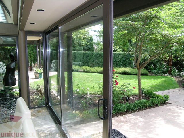 Bright living room with sliding glass doors leading to a lush garden. - 455 Keith Road, West Vancouver