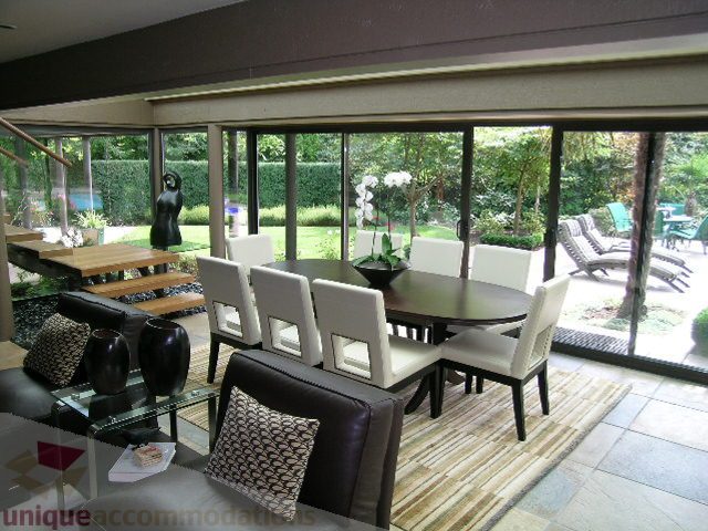 Furnished living room with large windows, outdoor view, and modern decor. - 455 Keith Road, West Vancouver