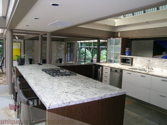 Bright kitchen with granite countertops and modern appliances, featuring a city view through large windows. - 455 Keith Road, West Vancouver