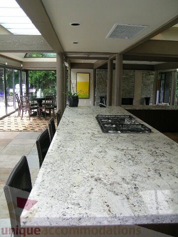Furnished kitchen with granite countertops and hardwood floors, leading to a patio area. - 455 Keith Road, West Vancouver