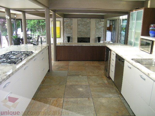 Bright kitchen with granite countertops and stone flooring, open to living area. - 455 Keith Road, West Vancouver