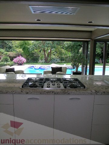 Bright kitchen with granite countertops and a view of the pool and garden. - 455 Keith Road, West Vancouver