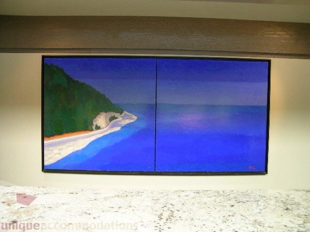 Furnished living room with a large abstract painting on the wall, featuring a coastal scene. - 455 Keith Road, West Vancouver