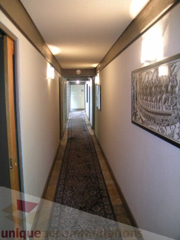 Furnished hallway with patterned rug and framed artwork. - 455 Keith Road, West Vancouver
