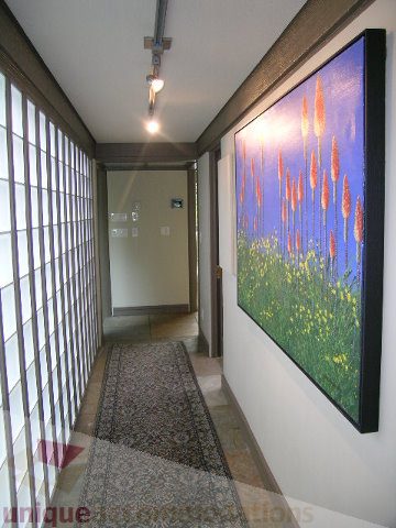 Framed artwork decorates a hallway with shoji-style sliding doors and a textured rug. - 455 Keith Road, West Vancouver
