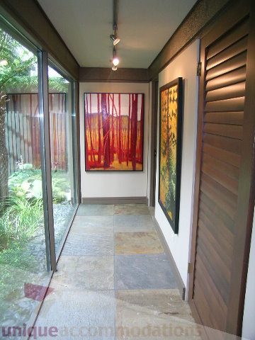 Furnished hallway with modern art and sliding wooden doors leading to a garden. - 455 Keith Road, West Vancouver