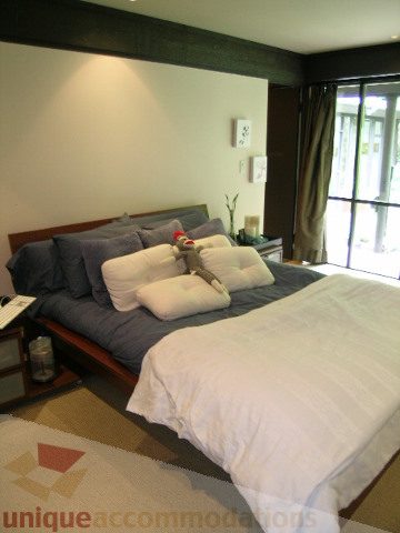Spacious bedroom with two queen beds, large windows, and neutral decor. - 455 Keith Road, West Vancouver