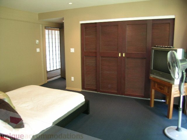 Furnished bedroom with built-in closet and desk area. - 455 Keith Road, West Vancouver