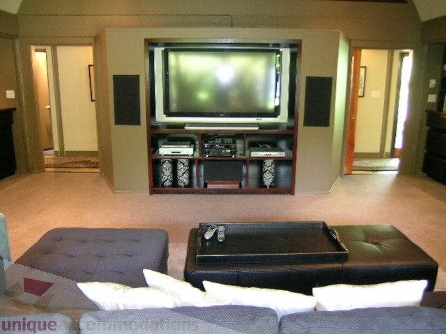 Living room with large TV, modern furniture, and hardwood floors. - 455 Keith Road, West Vancouver