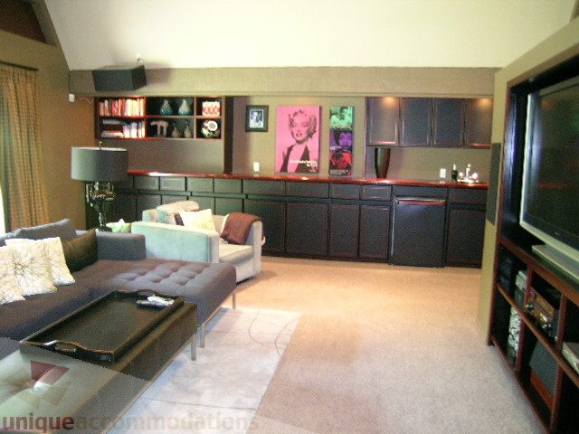 Furnished living room with a bar counter, modern decor, and a large flat-screen TV. - 455 Keith Road, West Vancouver