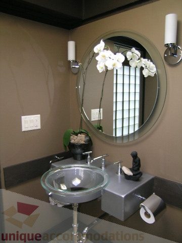 Modern bathroom with glass vessel sink and arched mirror. - 455 Keith Road, West Vancouver