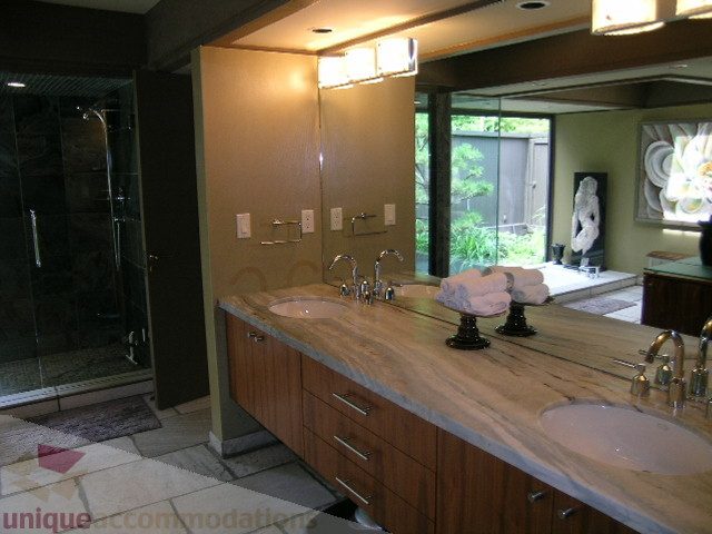 Bathroom with dual sinks, wooden cabinets, and large mirror. - 455 Keith Road, West Vancouver