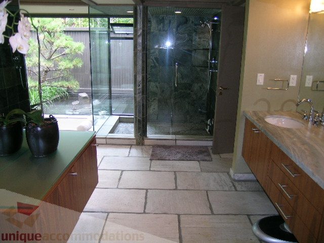 Spacious bathroom with stone countertops, glass shower, and natural light. - 455 Keith Road, West Vancouver