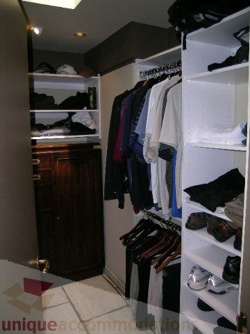 Furnished walk-in closet with neatly arranged clothes and shelves. - 455 Keith Road, West Vancouver