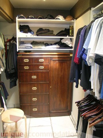 Furnished walk-in closet with wooden drawers and shelves, neatly organized. - 455 Keith Road, West Vancouver