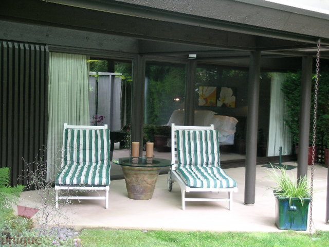 Furnished patio with striped furniture and greenery, perfect for relaxation. - 455 Keith Road, West Vancouver