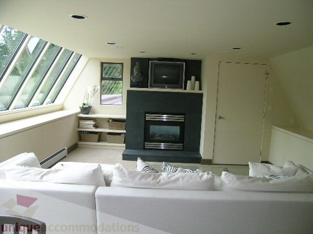 Bright living room with skylight, modern furniture, and a fireplace. - 455 Keith Road, West Vancouver