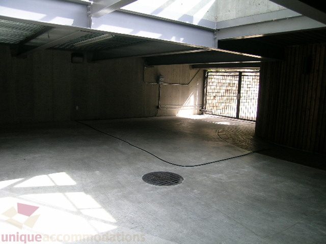 Large, unfinished basement with concrete floors and exposed beams. - 455 Keith Road, West Vancouver