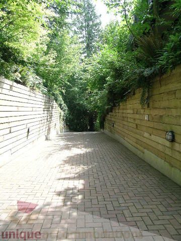 Furnished patio with brick paving and lush greenery. - 455 Keith Road, West Vancouver