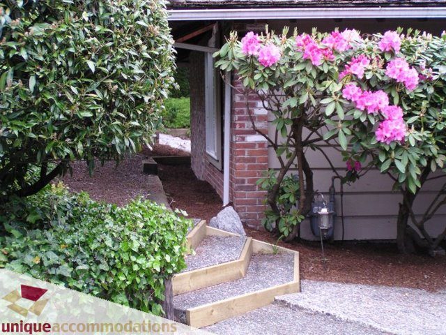 Furnished living room with cozy corner and vibrant flowers. - 3580 Westmount Court, West Vancouver