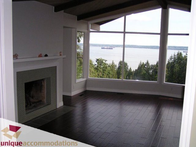Living room with hardwood floors, large windows, and a view of the water. - 3580 Westmount Court, West Vancouver