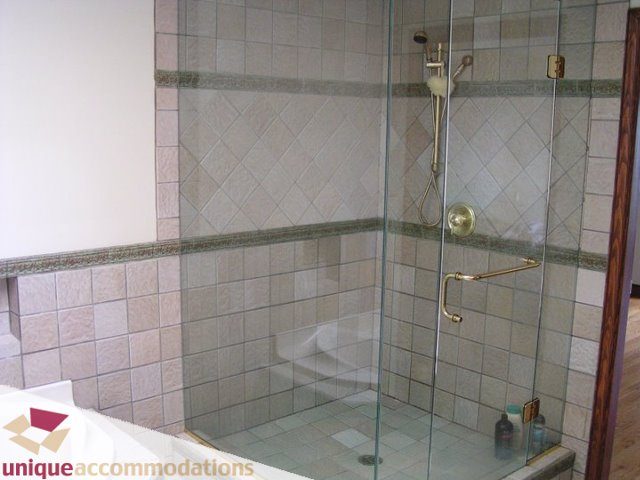 Bright bathroom with glass shower enclosure and tiled walls. - 3580 Westmount Court, West Vancouver