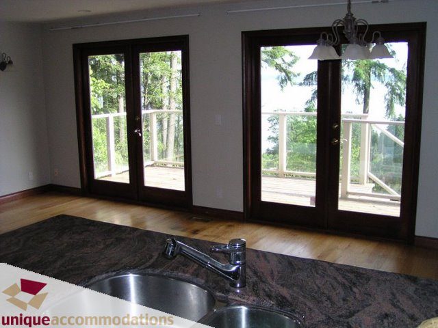 Bright kitchen with granite countertops, hardwood floors, and a view of the balcony. - 3580 Westmount Court, West Vancouver