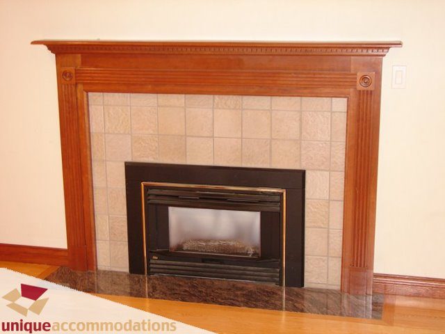 Furnished living room with wood-burning fireplace and hardwood floors. - 3580 Westmount Court, West Vancouver