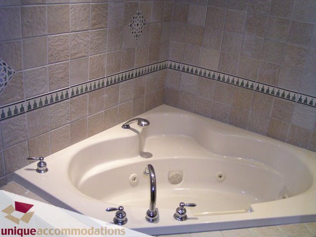 Bathroom with corner tub and decorative tile border. - 3580 Westmount Court, West Vancouver