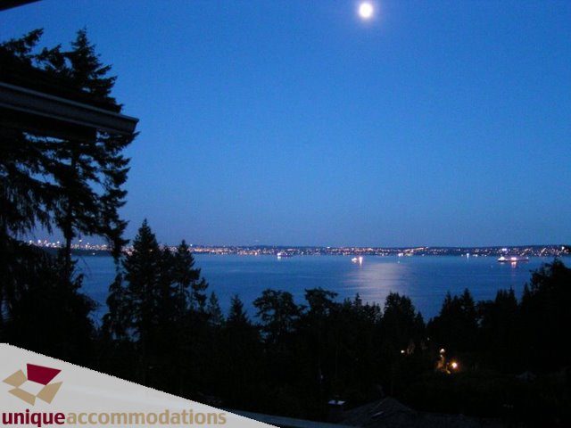 Bright living room with stunning city view and moonlit sky. - 3580 Westmount Court, West Vancouver