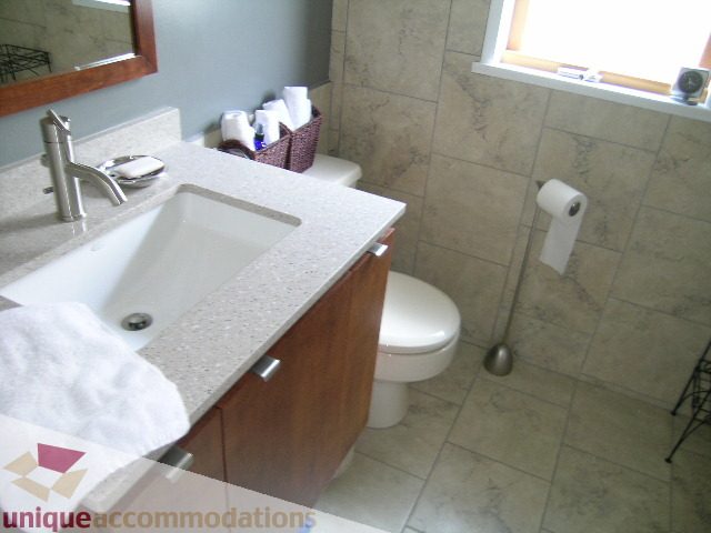 Bright bathroom with granite countertops and a window. - 408 E 7th Street, North Vancouver