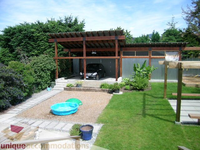 Furnished backyard with wooden pergola, grassy area, and small pool. - 408 E 7th Street, North Vancouver