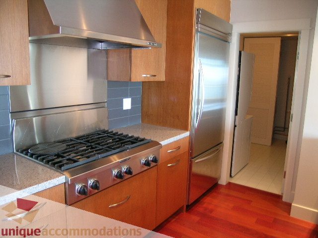 Bright kitchen with stainless steel appliances, granite countertops, and hardwood floors. - 1302 - 3355 Cypress Pl, West Vancouver