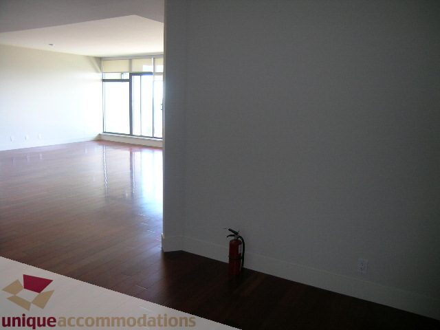 Bright living room with hardwood floors and a fire extinguisher. - 1302 - 3355 Cypress Pl, West Vancouver