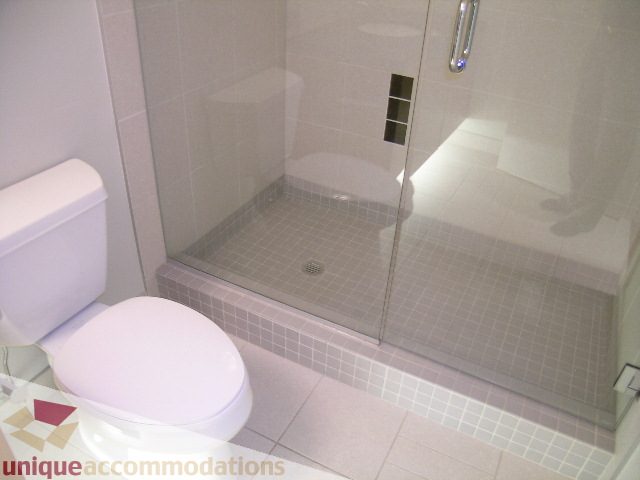 Modern bathroom with glass shower and tiled floor. - 1302 - 3355 Cypress Pl, West Vancouver