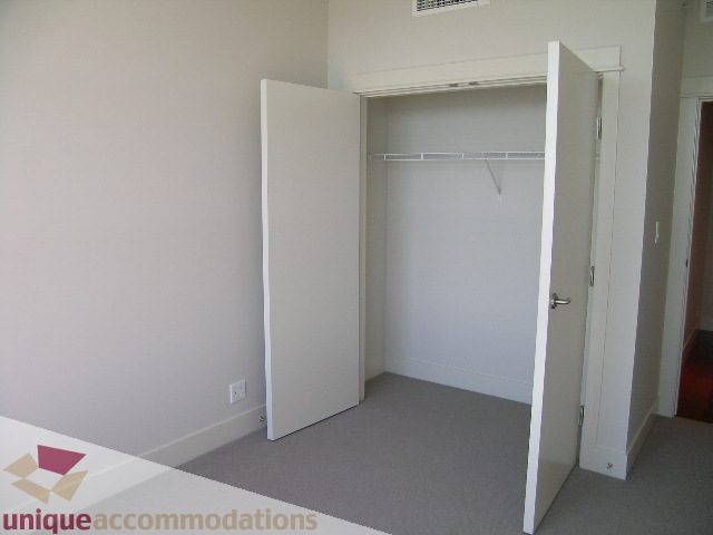 Bright bedroom with a large closet and white walls. - 1302 - 3355 Cypress Pl, West Vancouver