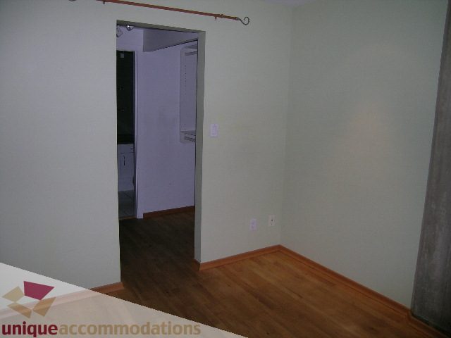 Bright living room with hardwood floors and a doorway leading to another room. - 402-1155 Mainland St, Vancouver Downtown