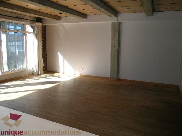 Bright living room with hardwood floors and large windows. - 402-1155 Mainland St, Vancouver Downtown