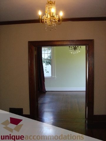 Furnished living room with hardwood floors and a chandelier, leading to another room with a window view. - 1475 W 33rd Ave, Vancouver West Side