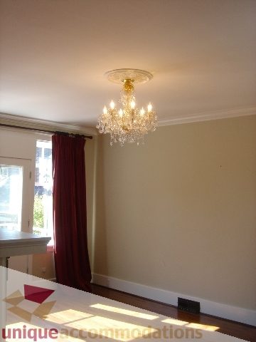 Dining room with elegant chandelier and red curtains. - 1475 W 33rd Ave, Vancouver West Side