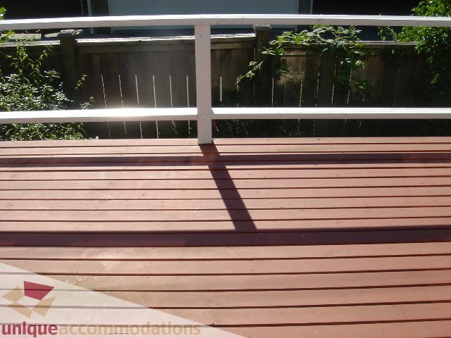 Furnished deck with wooden planks and white railing, sunlit. - 1475 W 33rd Ave, Vancouver West Side
