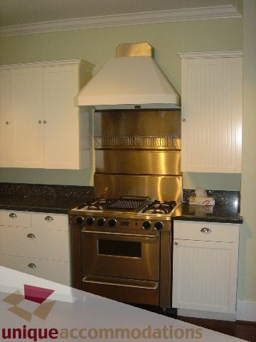 Bright kitchen with stainless steel appliances, granite countertops, and white cabinetry. - 1475 W 33rd Ave, Vancouver West Side