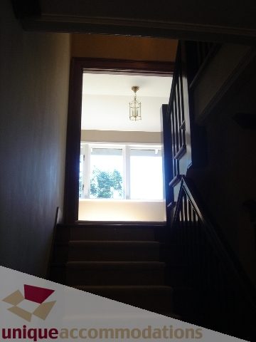 Staircase leading to upper level with wooden banister and natural light from above. - 1475 W 33rd Ave, Vancouver West Side