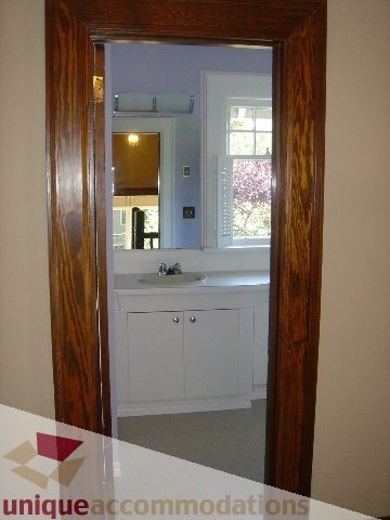 Bathroom with wooden door frame and white cabinets. - 1475 W 33rd Ave, Vancouver West Side