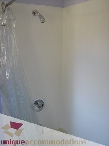Bathroom with shower curtain and wall-mounted showerhead. - 1475 W 33rd Ave, Vancouver West Side