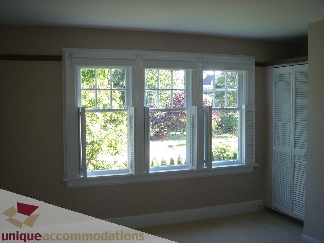 Bright sunroom with large windows and shutters, showcasing a view of greenery and trees. - 1475 W 33rd Ave, Vancouver West Side